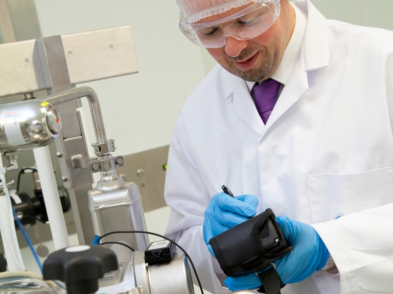Improve the availability of your pharmaceutical plant with expert asset support Employee of a pharma company analyzing installed equipment